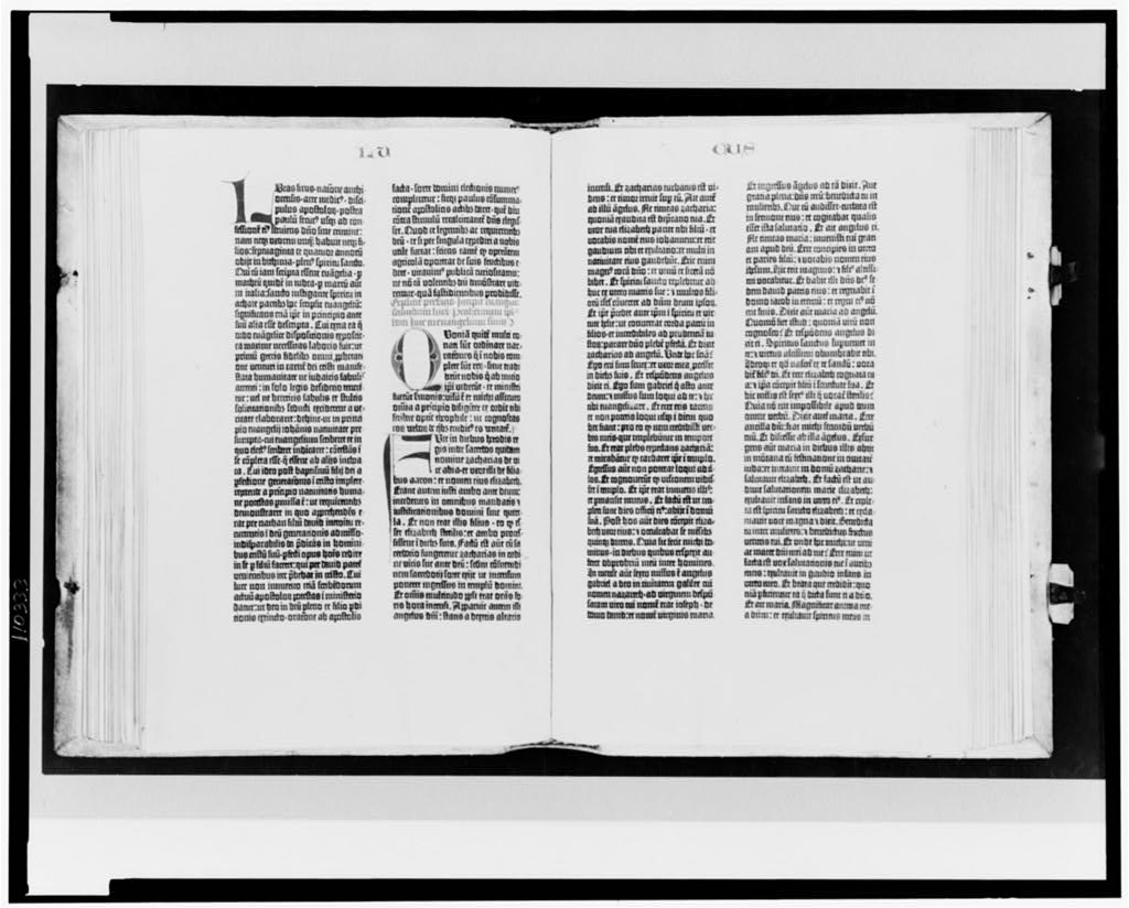 A page from the Gutenberg Bible: two dense columns of black Gothic blackletter type with hand-painted red and blue initials, on cream-coloured vellum.