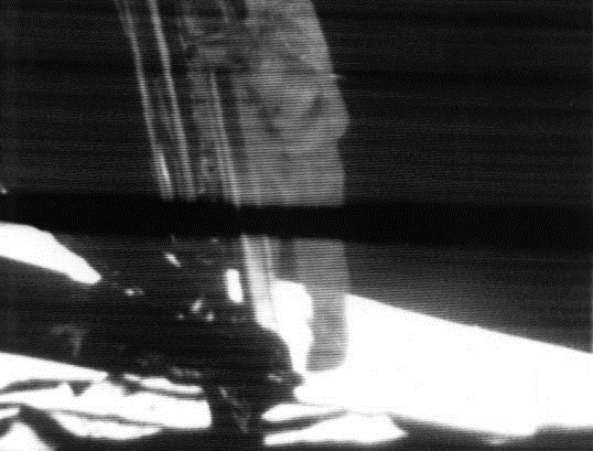 A grainy black-and-white television still showing Neil Armstrong, in a white pressure suit, descending the ladder of the Apollo 11 lunar module to step onto the surface of the Moon.